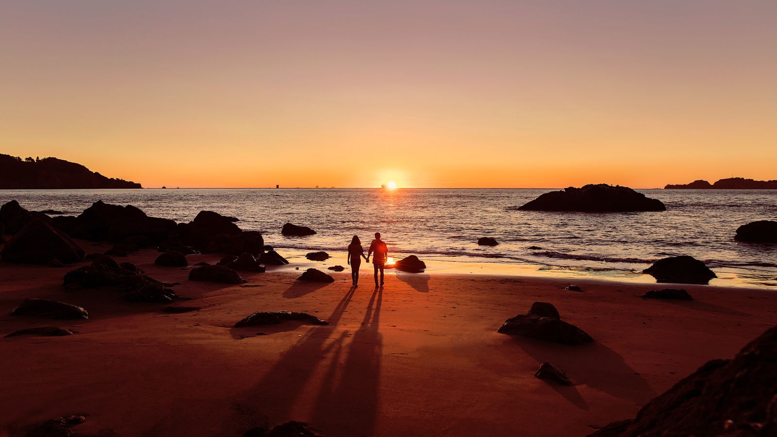 Couple strolling at a beach hand in hand