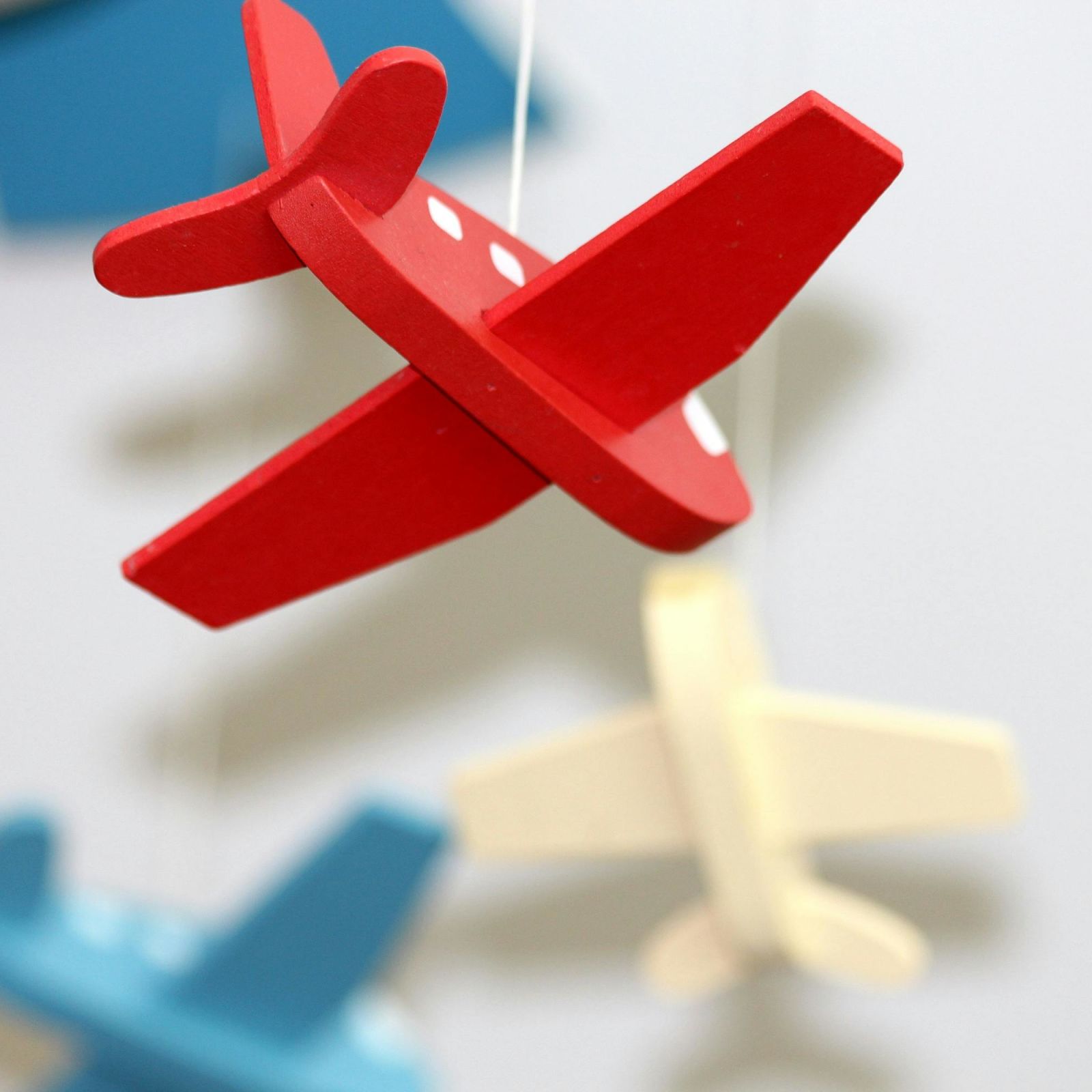 Colourful wooden toy air planes hanging in a room