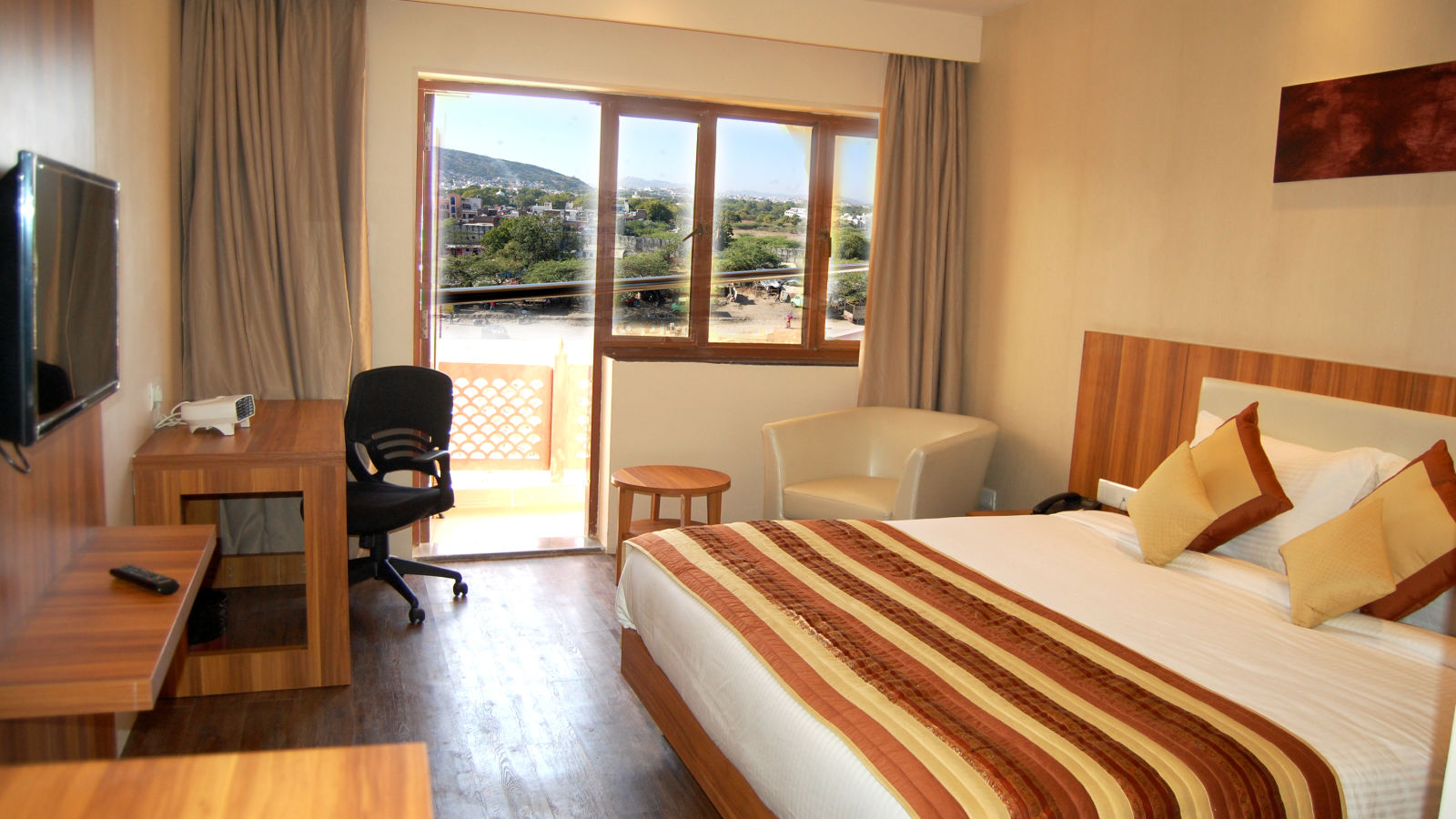 Deluxe Silver Rooms with Balcony along with a posh bed and warm interiors - le roi udaipur hotel3