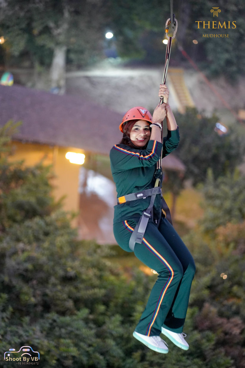 A woman zip lining at Themis Mudhouse - A Nature's Retreat Resort & Wellness