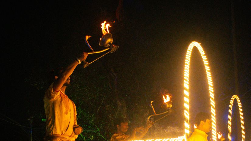 a priest performing aarti during an temple event in the night