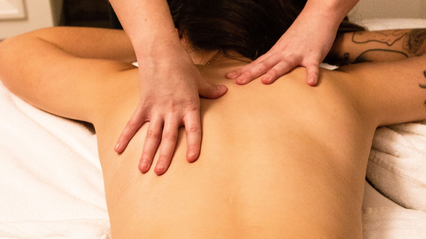 person receiving back massage from a masseur