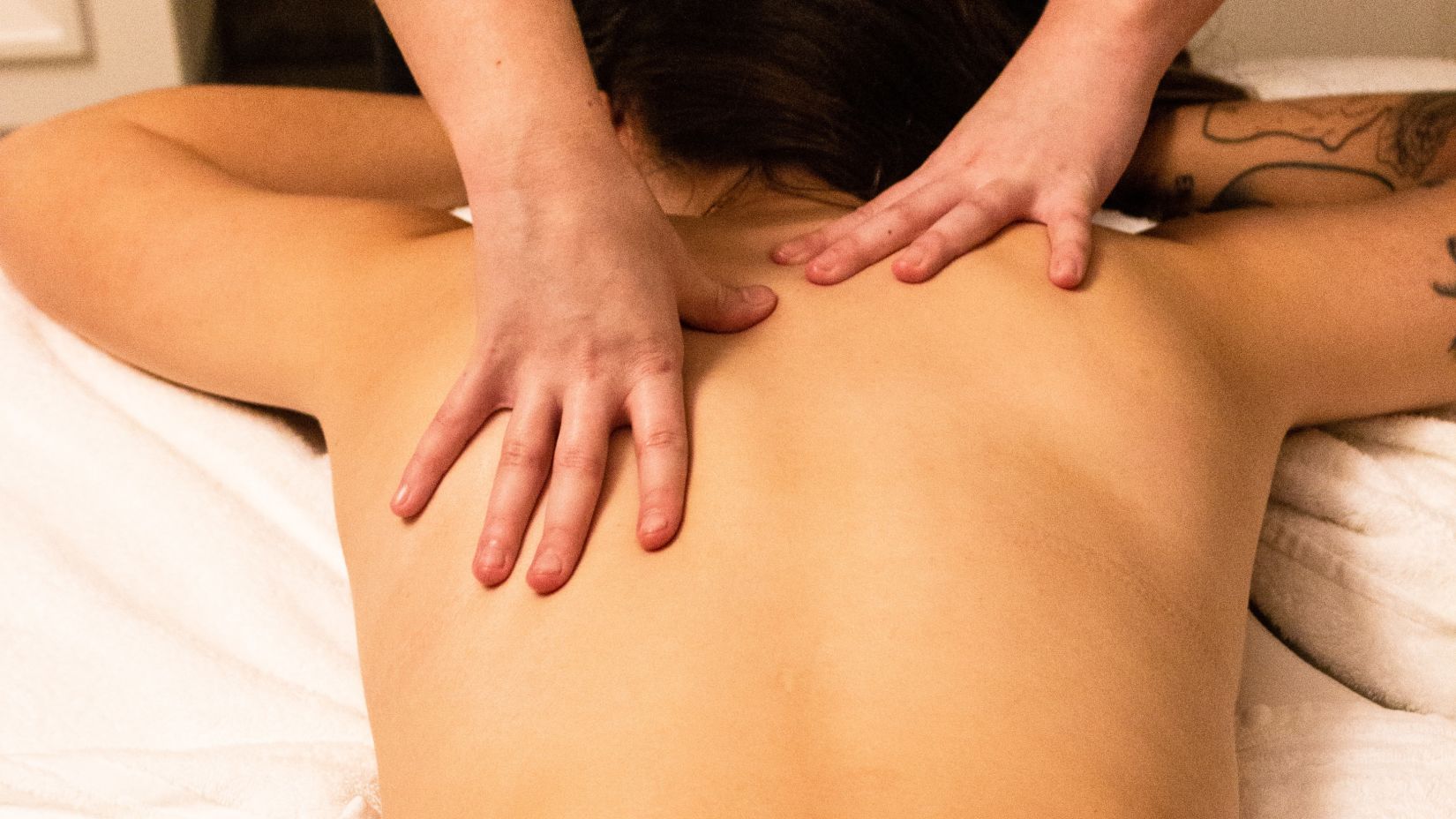 person receiving back massage from a masseur