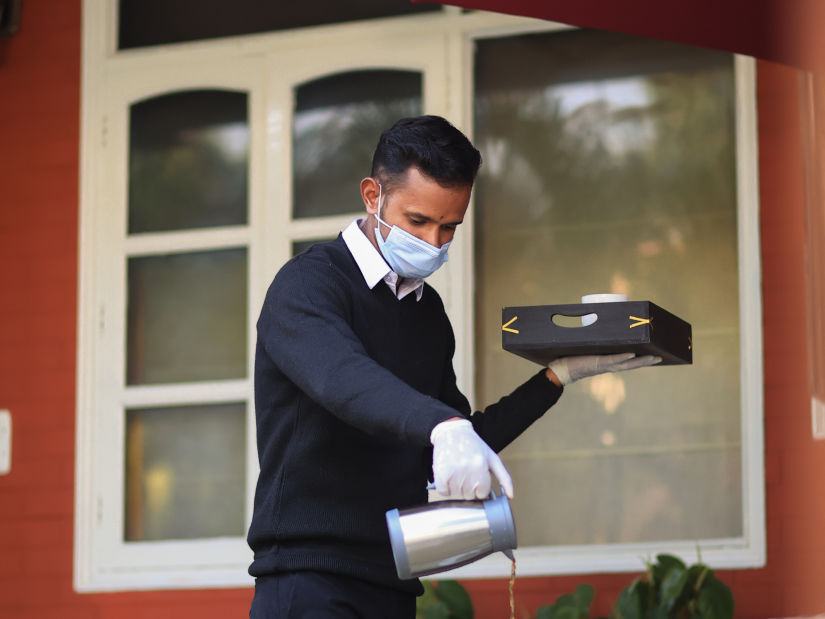 Our highly-trained staff prepping the table for tea time - Lamrin Boutique Cottages Rishikesh