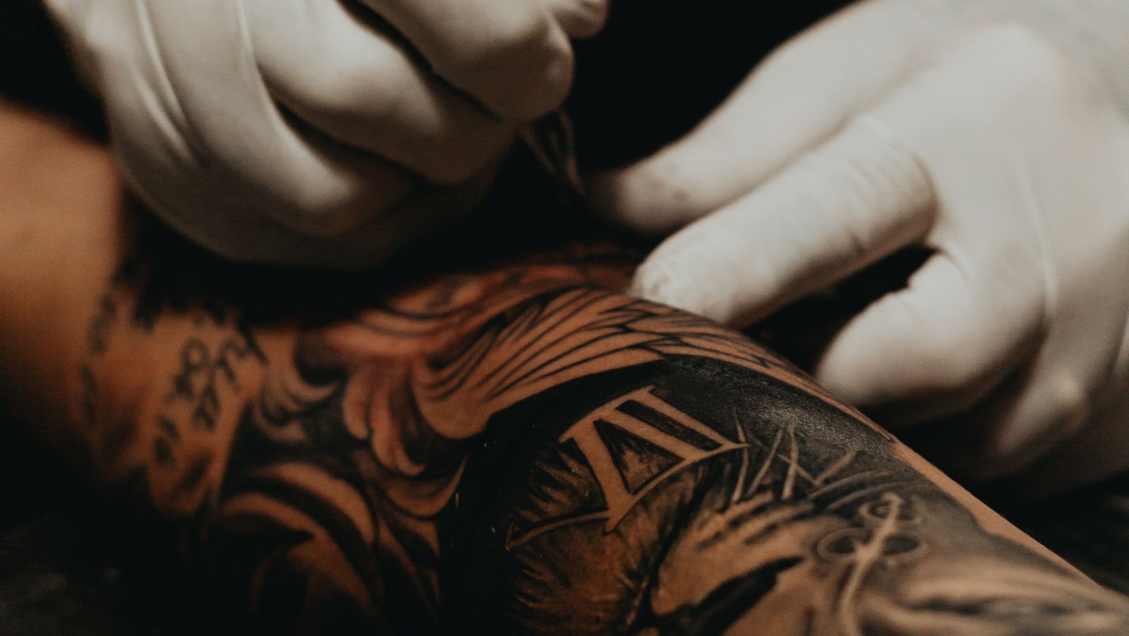 A tattoo artist working on a tattoo on a client's hand at Goa Tattoo Festival