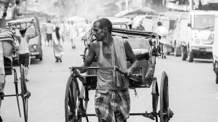 a man manoeuvring a hand-pulled rickshaw in Kolkata