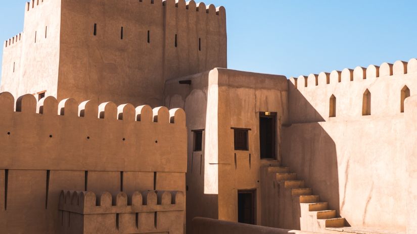 A fort with doors and steps leading to different rooms inside and the blue sky in the background