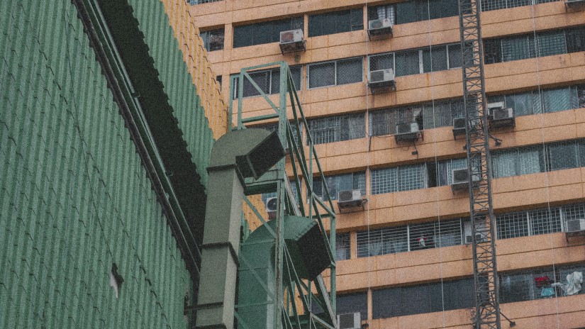 A low-angle shot of a tall industrial building with glass windows