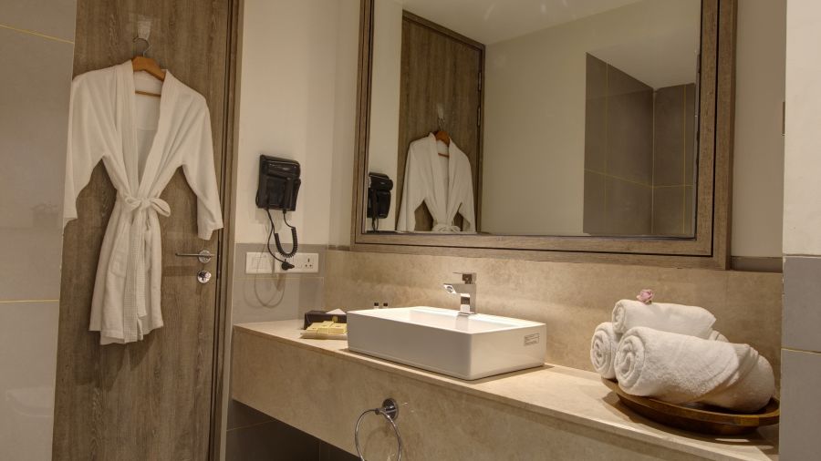 overview of the bathroom of Two bedroom Executive Suite with a bathrobe kept on a hanger