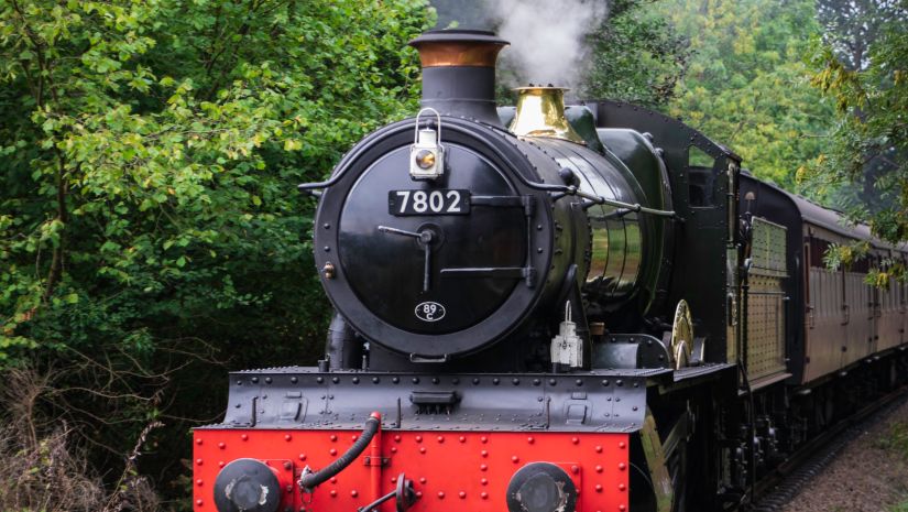 An old train that runs on charcoal going through a forest