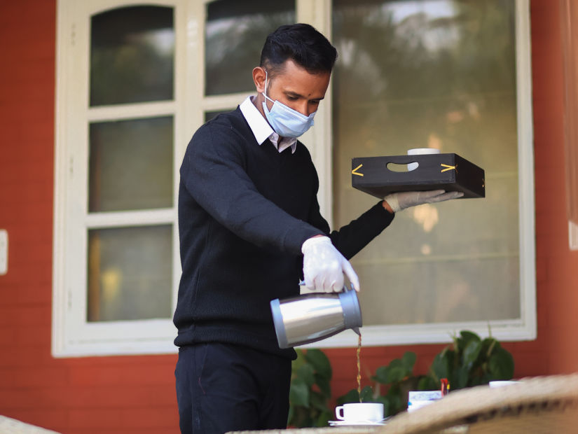 Our highly-trained staff prepping the table for tea time - Lamrin Boutique Cottages Rishikesh