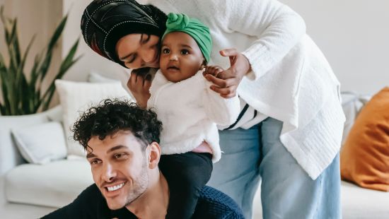 A couple accompanied by their adorable baby enjoys quality time together in the comfort of their room - family resort in Goa