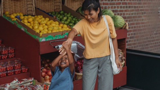 a parent and child at a fruit stall