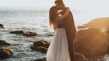 couple embracing with the ocean in the backdrop