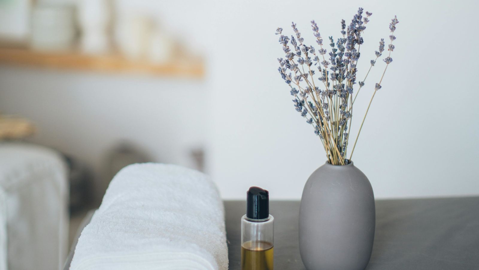 Towel, essential oil and diffuser kept on a table in a spa