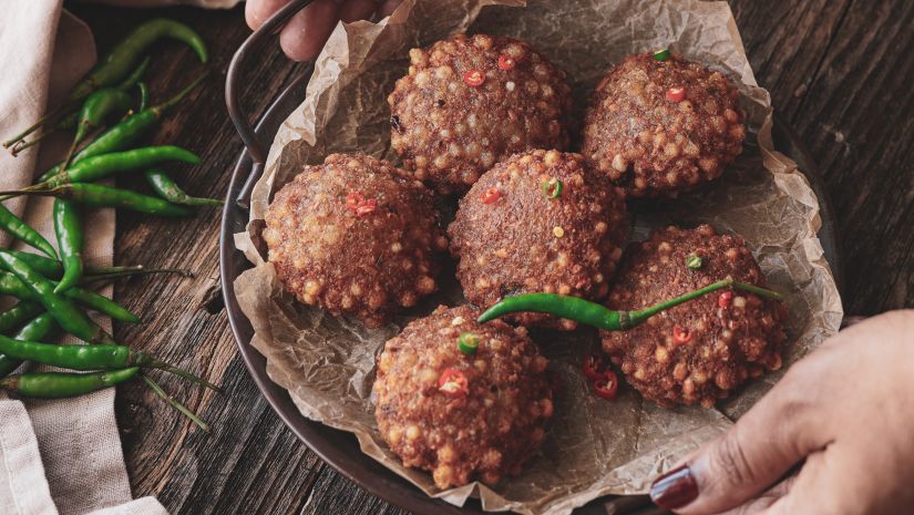 A woman serving a tray of sabudana vada