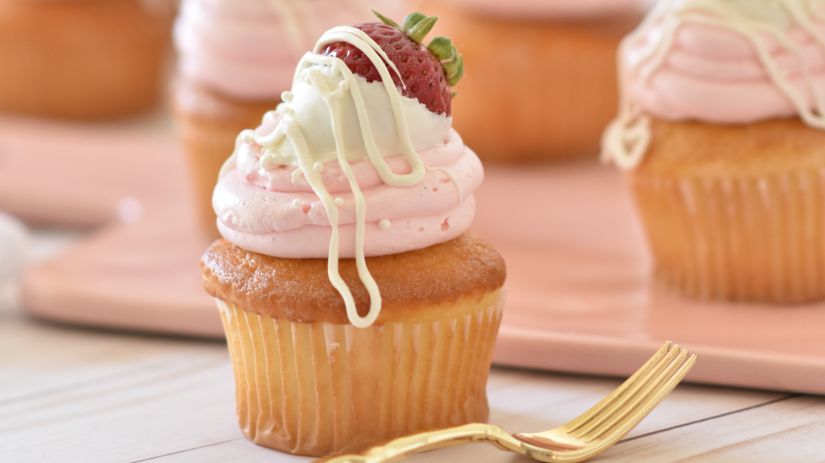 a wooden table filled with cupcakes