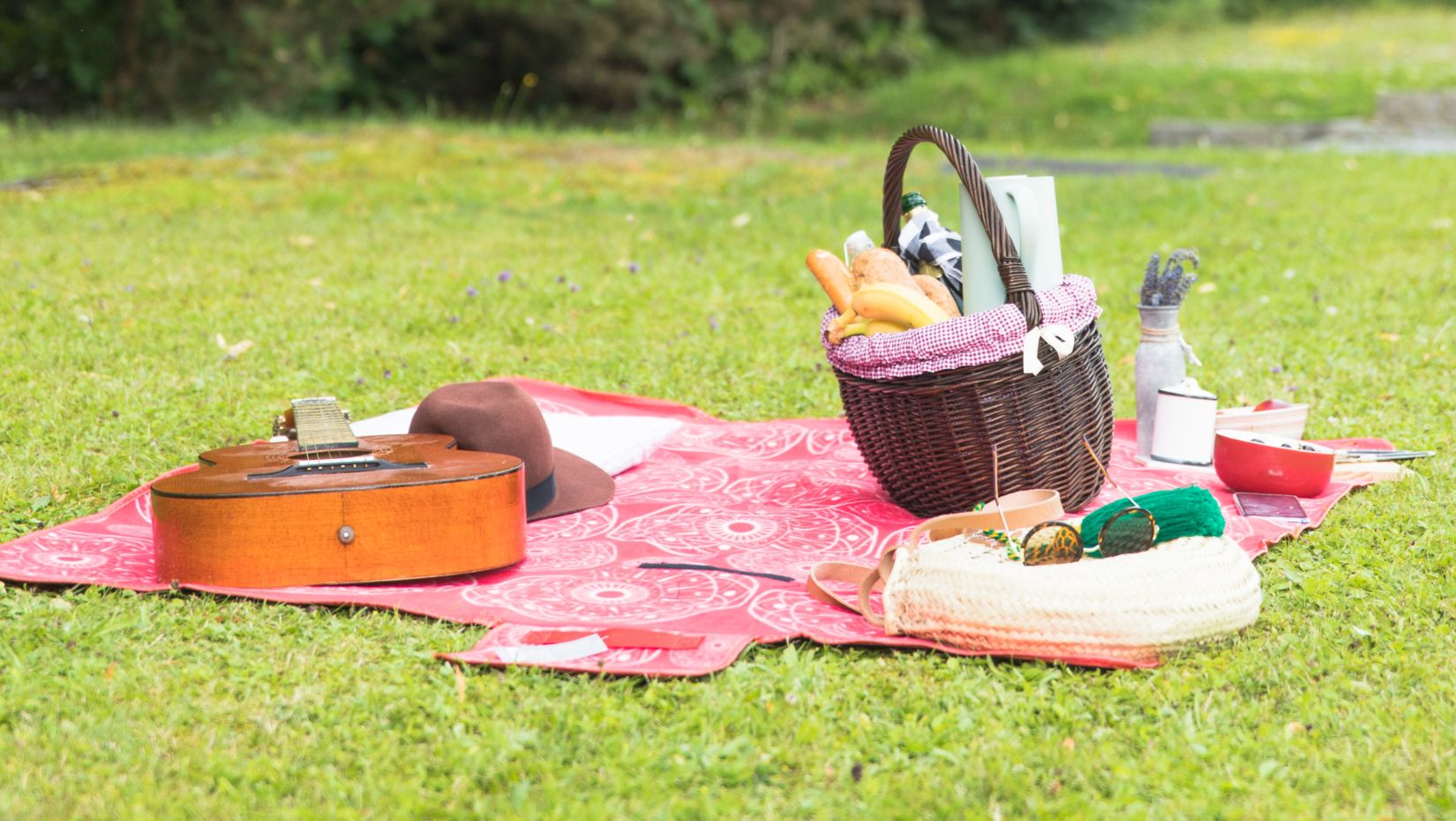 picnic-basket-filled-with-food-with-personal-accessory-blanket-green-grass