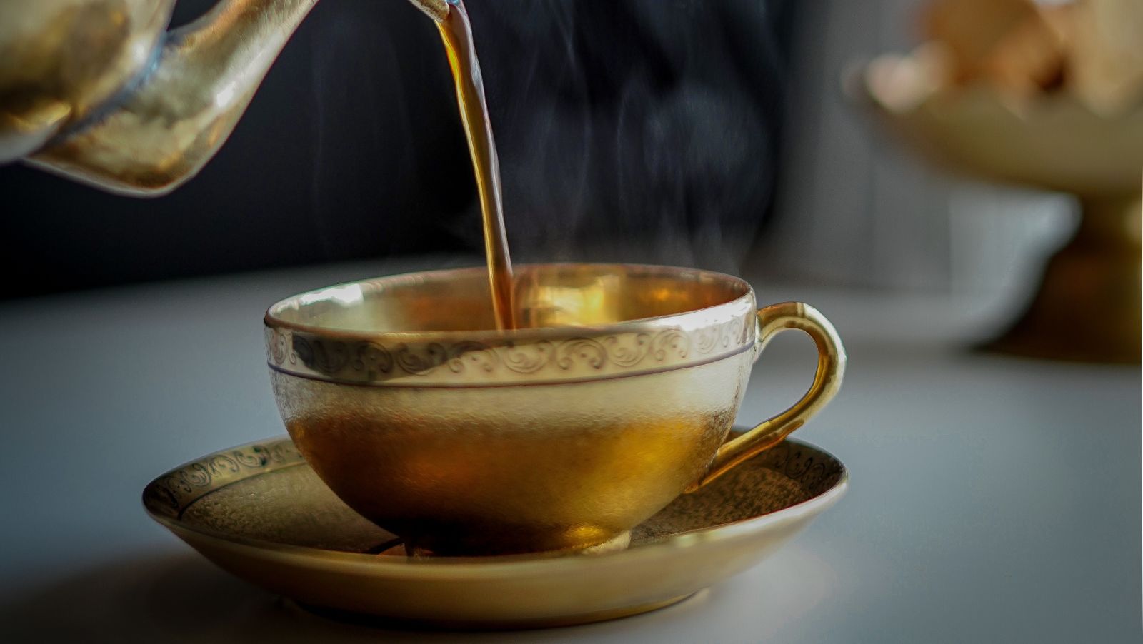 Tea being poured into the cup from the teapot