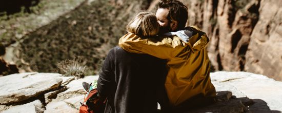 alt-text couple sitting on cliff