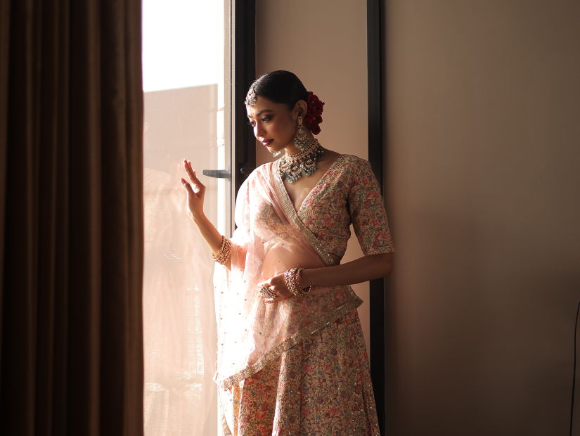 Bride in traditional attire by window