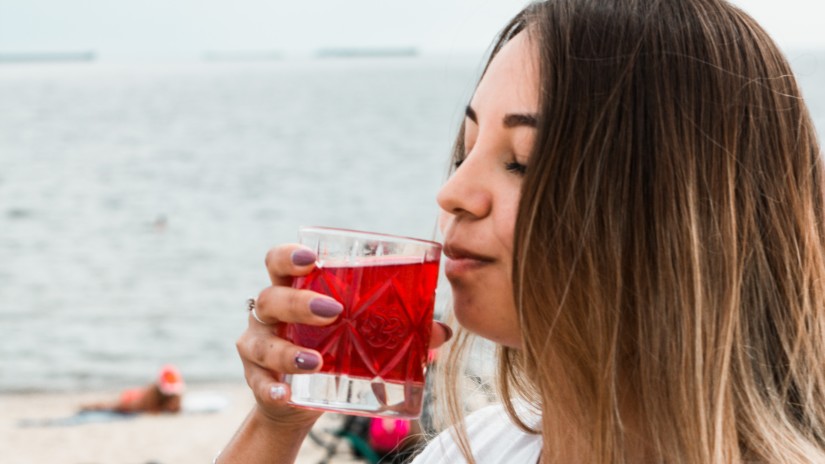 Woman having a drink on the beach - reference image