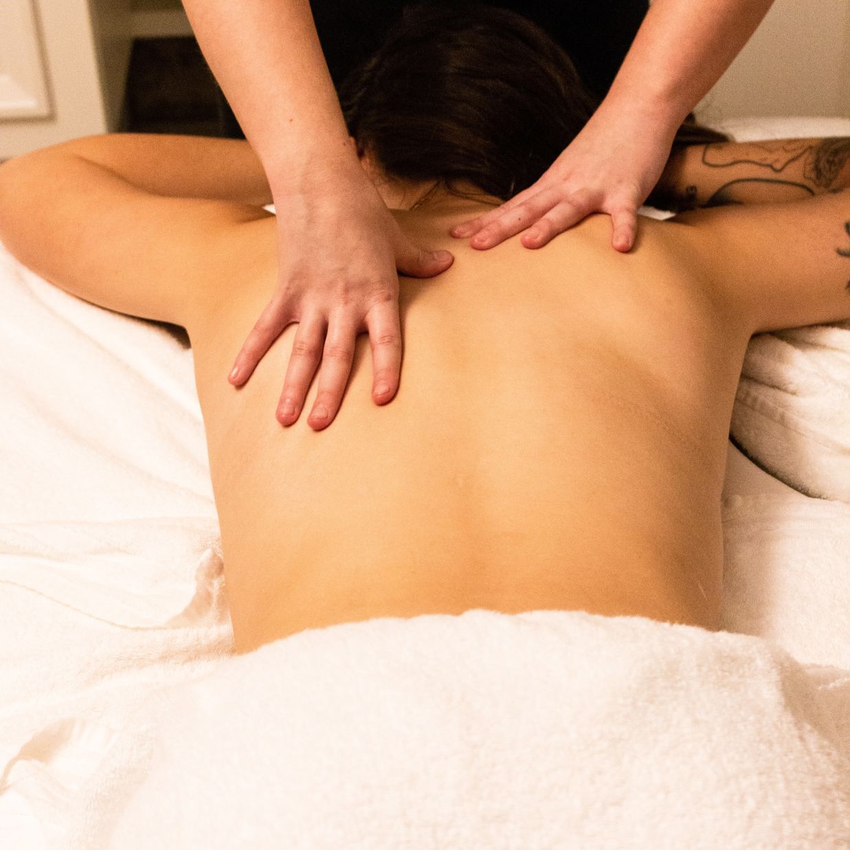 person receiving back massage from a masseur