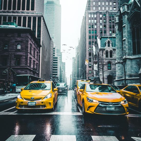 A long shot of taxis moving around on the road