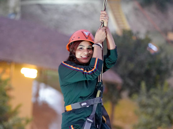 A woman zip lining at Themis Mudhouse - A Nature's Retreat Resort & Wellness