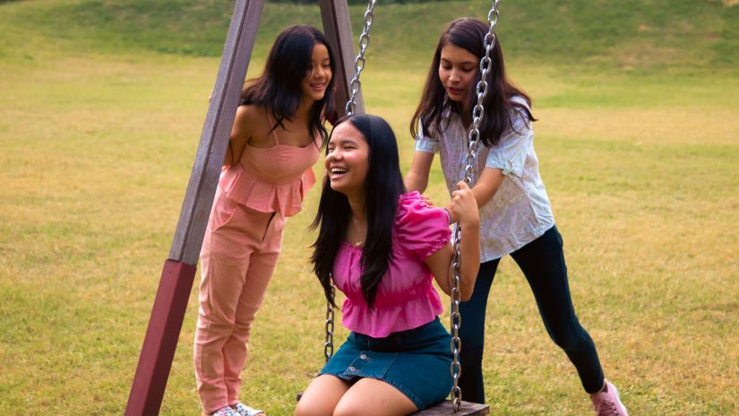 kids playing on a swing in playground