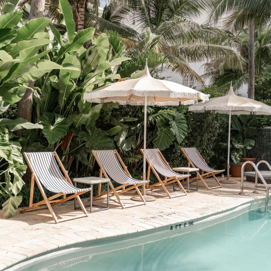 A view of the outdoor swimming pool with sun lounger on the deck