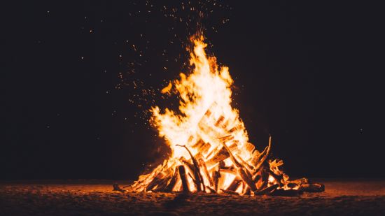 A low angle shot of campfire flickering at night