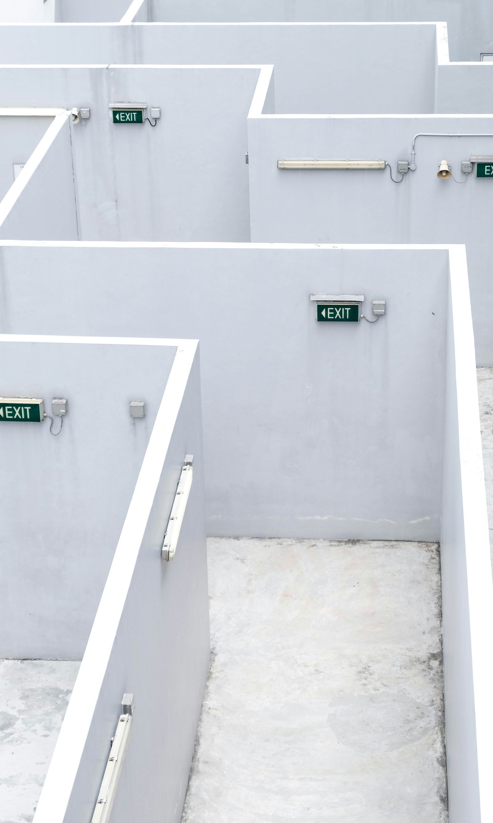 top view of a maze with exit signs on the white walls