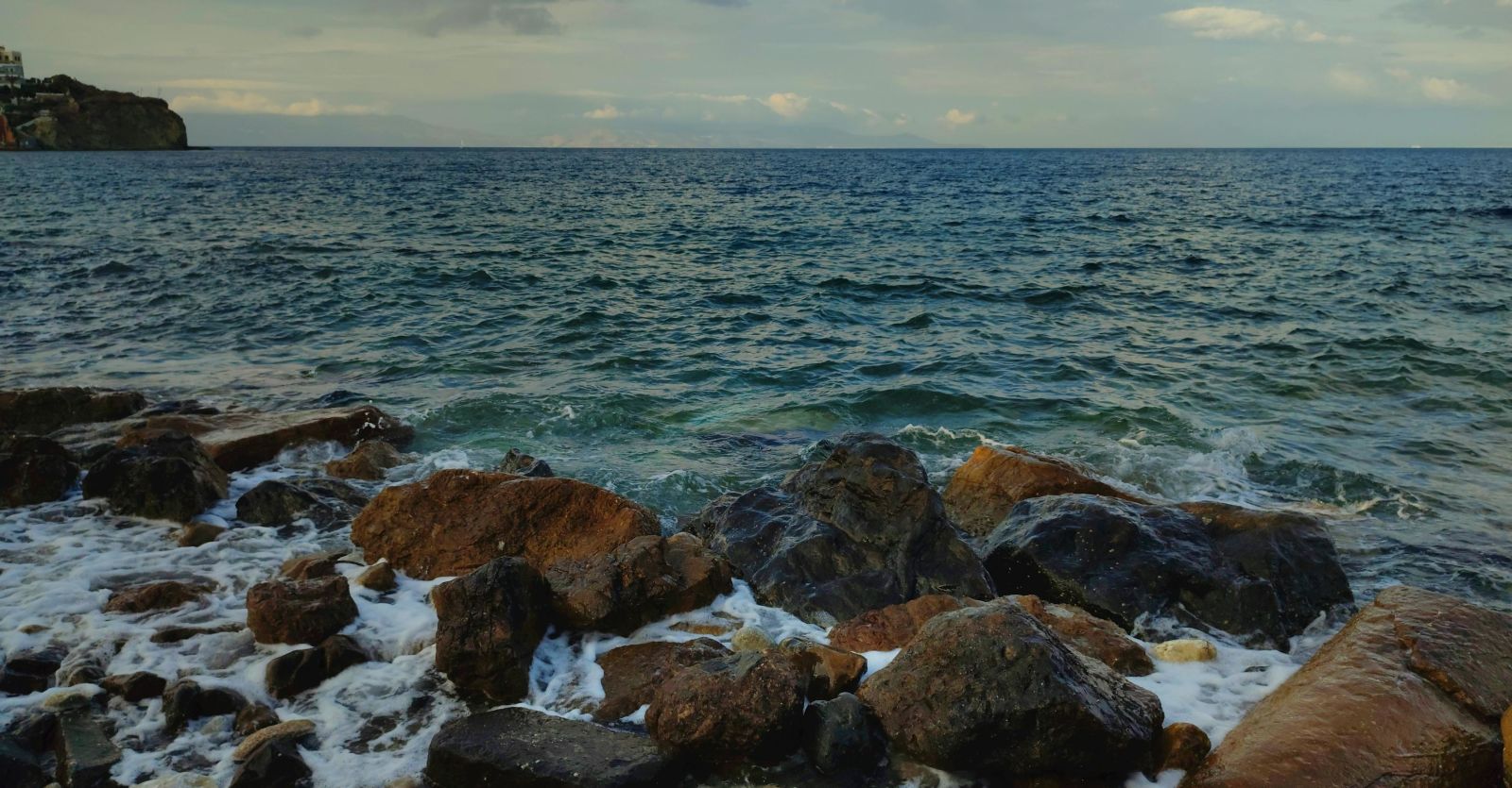 An image of a seaside where shores are hitting the rocks | Ocean Spray