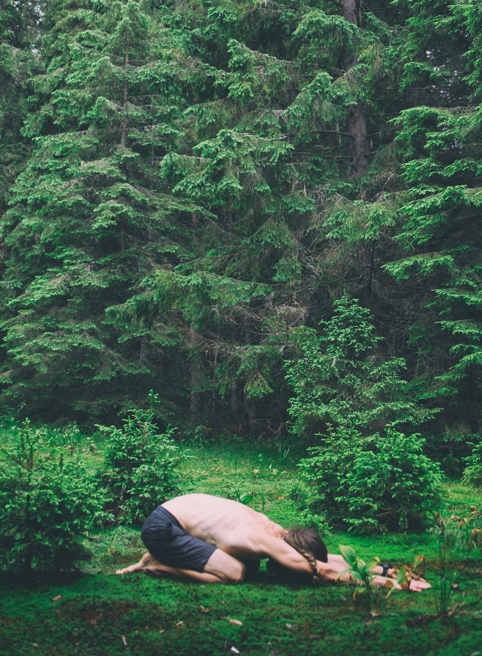 a person performing a yoga asana of child's pose amidst nature