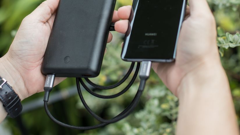 man holding his phone and power bank