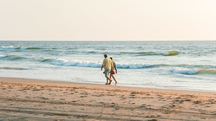 a couple walking by the beach