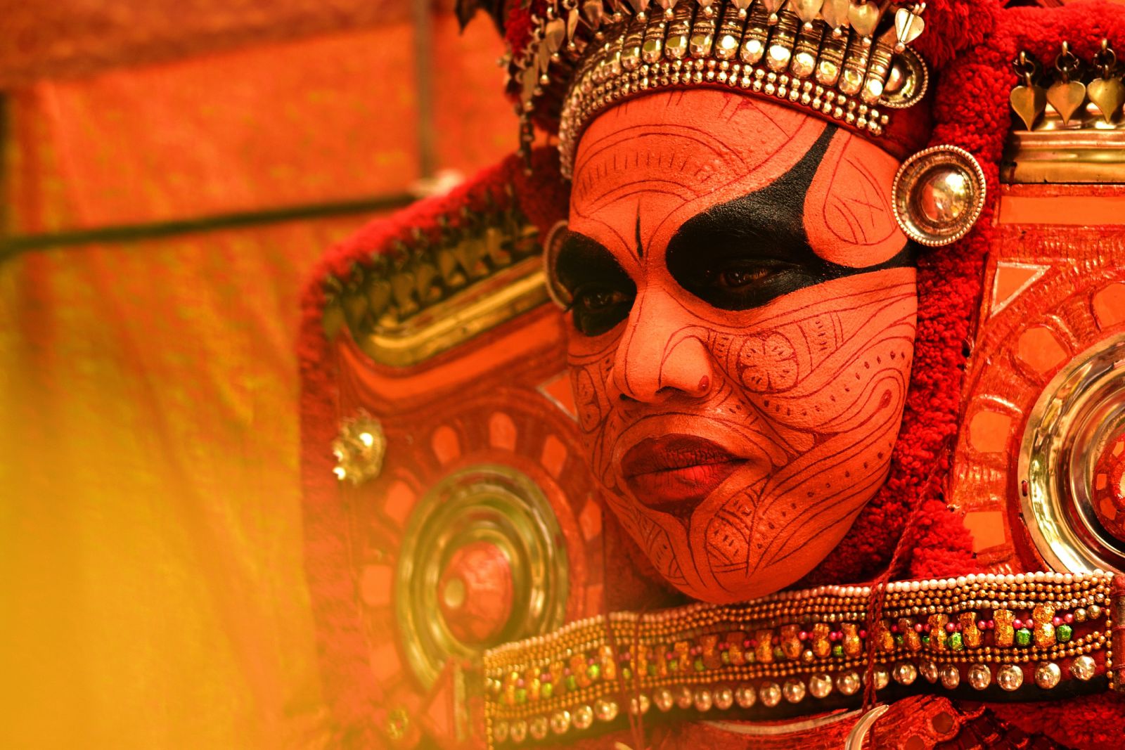 The painted face of a man who perform Theyyam an artform in Kerala - Kumarakom Tourism