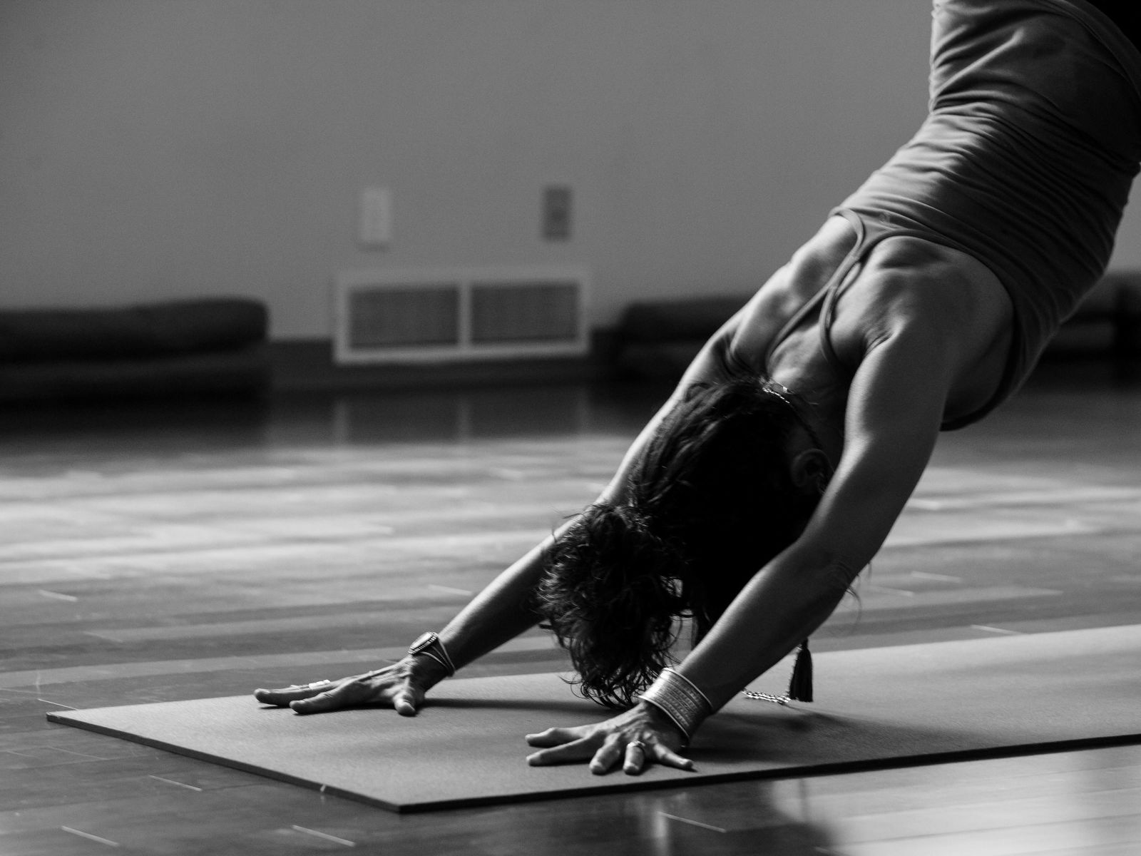 A black and white image of a person performing yoga on a mat