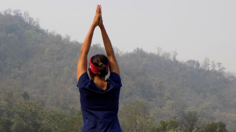 a person practicing yoga on the bank of river