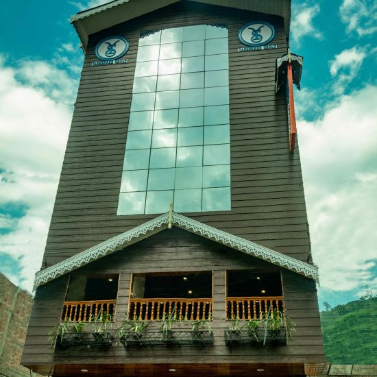 A low high shot of a building with glass elevation | Sumi Yash Shree Hotels & Resorts