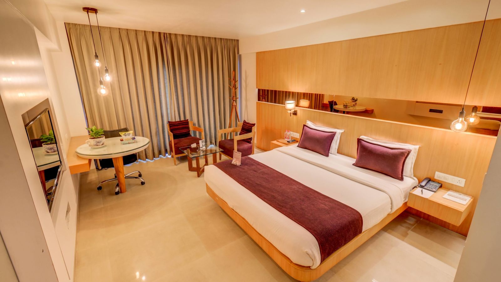 a view of the king sized bed and seating area at Deluxe room at SSK Solitaire Hotel And Banquets