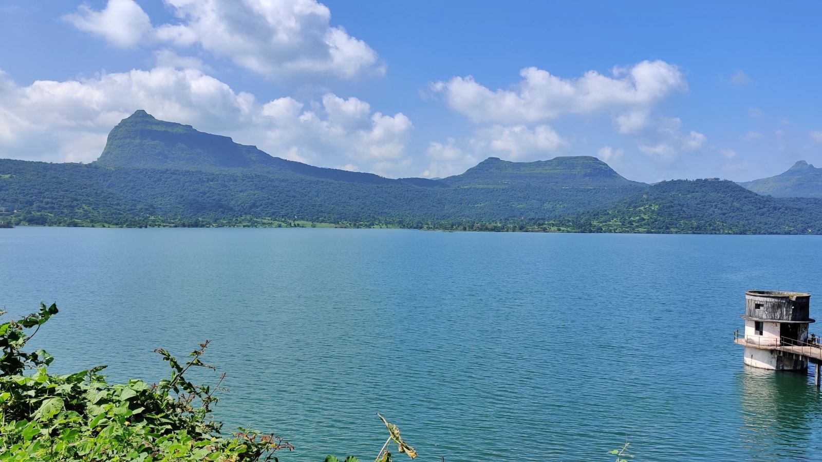 a crystal blue lake overlooking a mountain during daytime