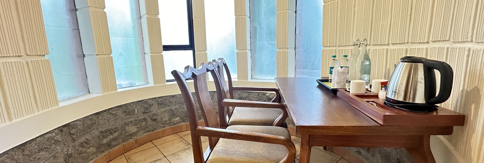 a workdesk with a tea kettle and chairs  - Kadkani River Resort, Coorg