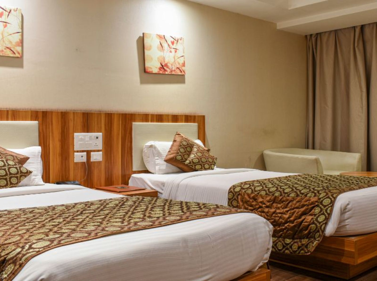 corporate room with twin beds and warm lighing at le roi raipur hotel