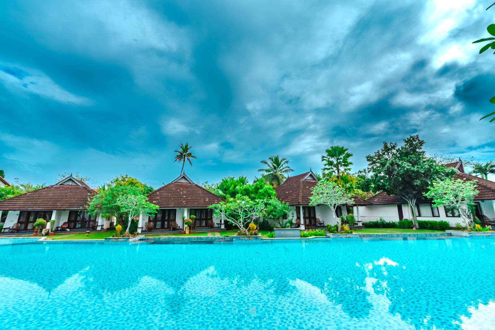 bunch of cottages surrounded by a big swimming pool