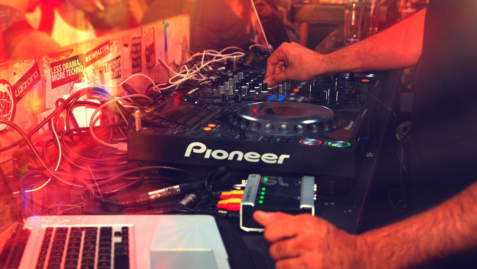 A close up image of the equipments used by a DJ during a party with a laptop and a turntable in view