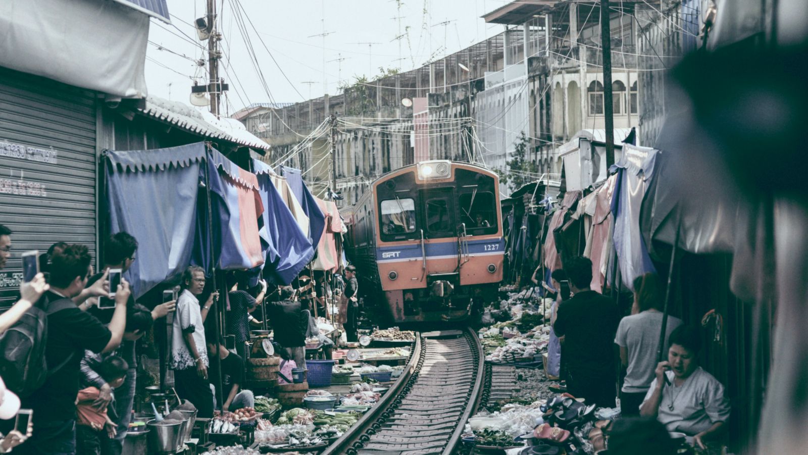 an overview of the train market with people making space for the train to move