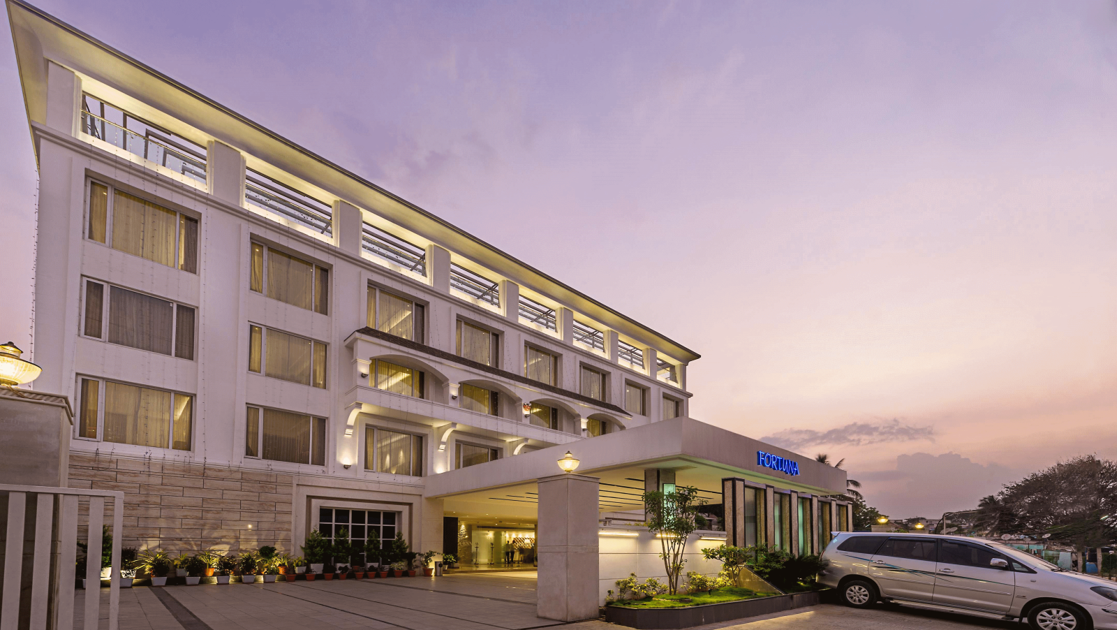 The exterior of the TGI Grand Fortuna Hotel during twilight, showcasing its entrance and facade - TGI Grand Fortuna, Hosur