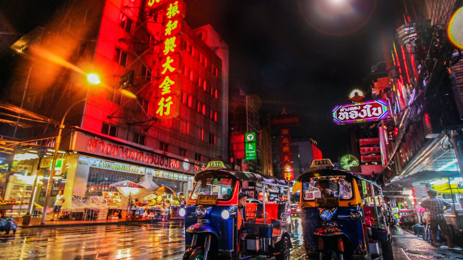 tuk tuks parked on a street in Bangkok